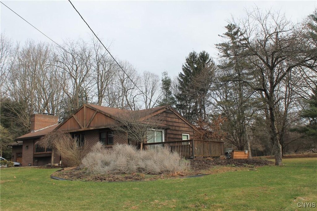 view of property exterior with a lawn and a deck