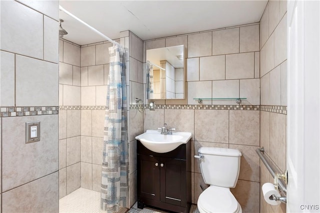 bathroom featuring walk in shower, vanity, toilet, and tile walls