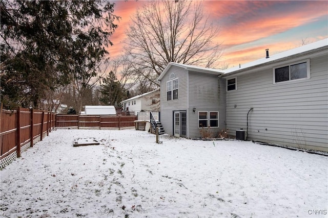 snow covered property with cooling unit