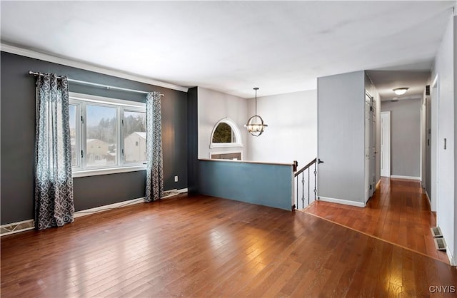 spare room featuring dark hardwood / wood-style flooring and an inviting chandelier