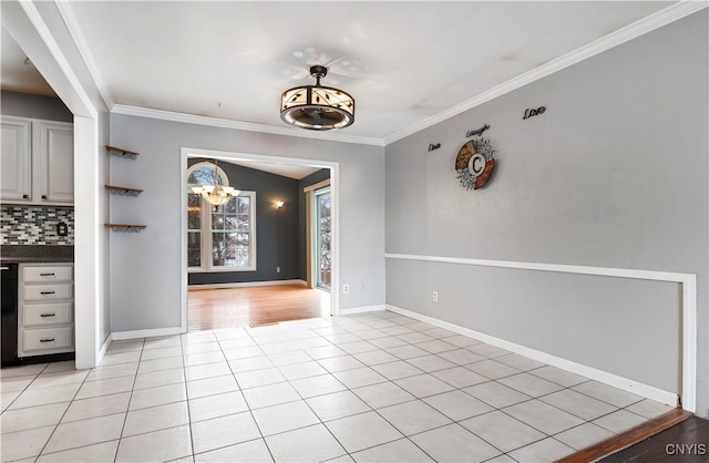 unfurnished dining area featuring light tile patterned floors, ornamental molding, and an inviting chandelier