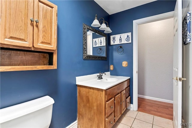 bathroom with tile patterned flooring, vanity, and toilet