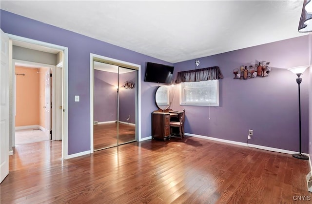 unfurnished bedroom with hardwood / wood-style flooring and a closet