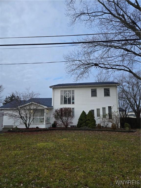 view of front of home featuring a sunroom and a front yard