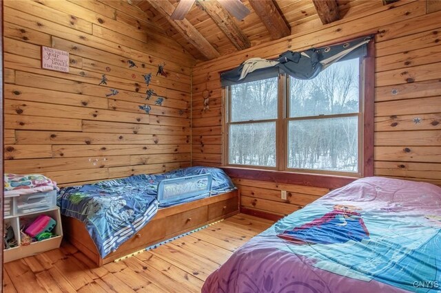 bedroom with hardwood / wood-style floors, lofted ceiling with beams, wood walls, and wood ceiling