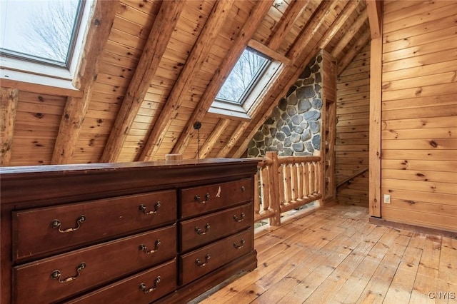 bonus room with wooden walls, light hardwood / wood-style flooring, wooden ceiling, and vaulted ceiling with skylight