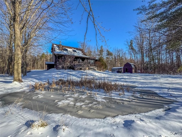 snow covered property featuring an outbuilding