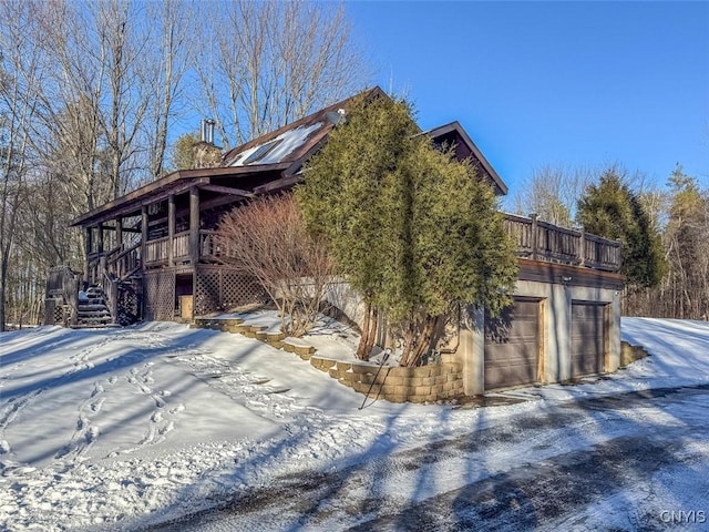 view of snowy exterior with a garage