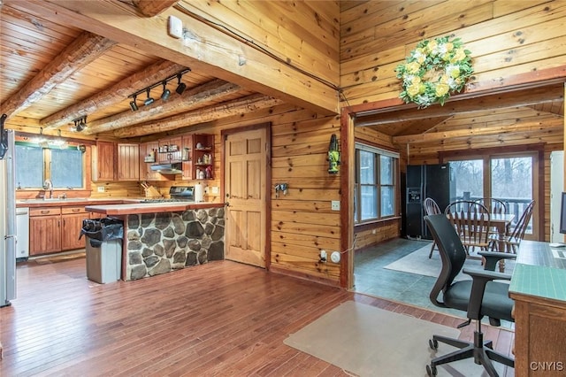 home office with dark hardwood / wood-style floors, beam ceiling, wooden ceiling, and wooden walls