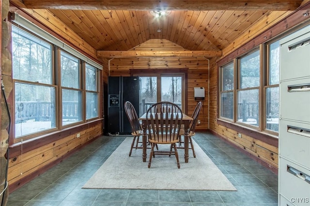 dining space featuring dark tile patterned flooring, lofted ceiling, wood ceiling, and wooden walls