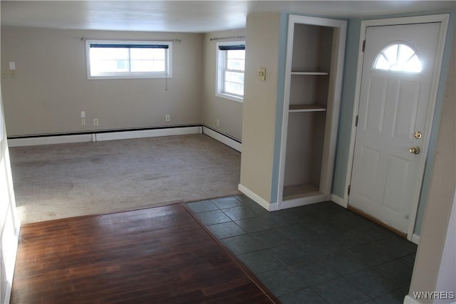 entrance foyer with dark tile patterned floors and a healthy amount of sunlight