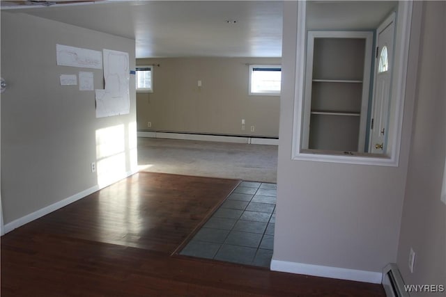 unfurnished room featuring wood-type flooring and baseboard heating