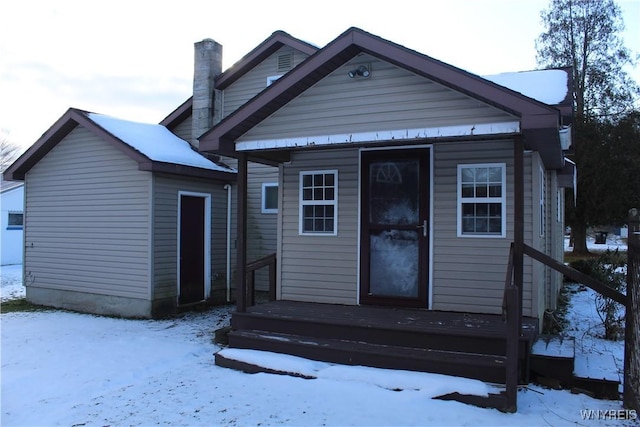 view of snow covered rear of property