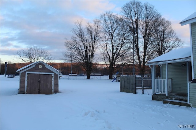 snowy yard with a storage shed