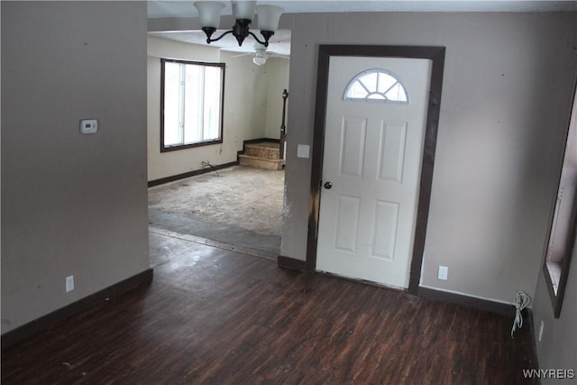 foyer entrance with dark hardwood / wood-style flooring and a chandelier