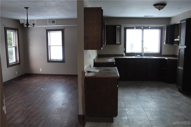 kitchen featuring wood-type flooring, plenty of natural light, a notable chandelier, and sink