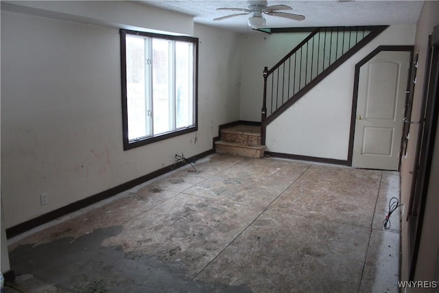 foyer featuring ceiling fan and a textured ceiling