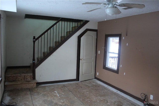 interior space with a textured ceiling and ceiling fan