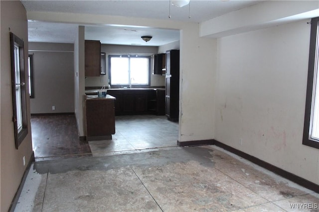 kitchen featuring black fridge, sink, and dark brown cabinets