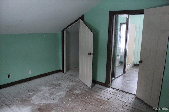 unfurnished bedroom featuring light wood-type flooring and vaulted ceiling