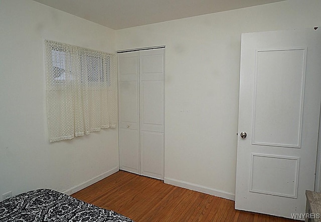 unfurnished bedroom with a closet and hardwood / wood-style flooring