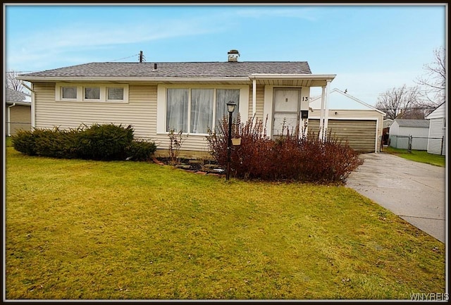 view of front facade with an outbuilding, a garage, and a front lawn