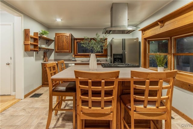 kitchen with stainless steel fridge with ice dispenser, island range hood, black gas stovetop, and sink