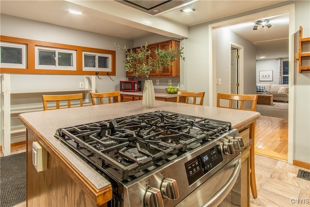 kitchen with light hardwood / wood-style floors, high end stainless steel range oven, and a kitchen island