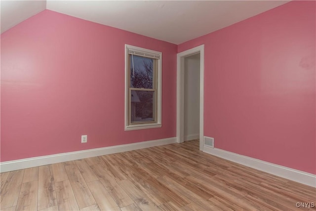 empty room featuring light hardwood / wood-style flooring and lofted ceiling