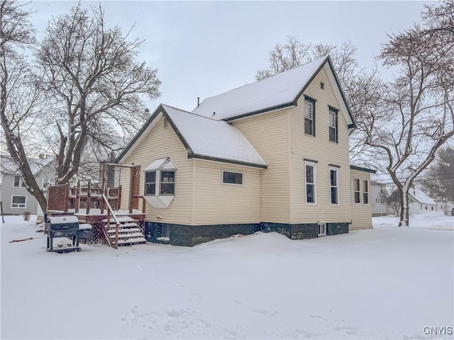 view of snowy exterior with a wooden deck