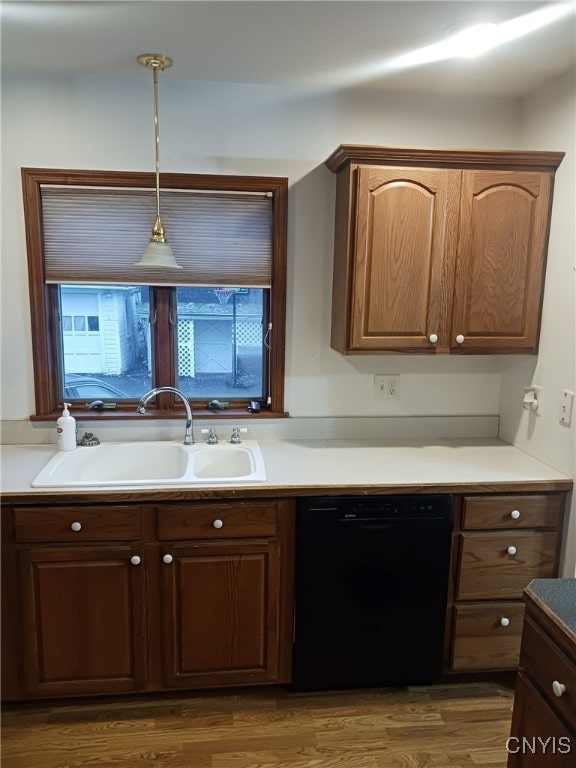 kitchen featuring pendant lighting, dishwasher, dark hardwood / wood-style flooring, and sink