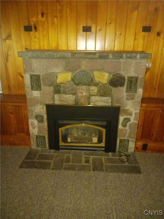 interior details with wood walls, carpet floors, and a fireplace