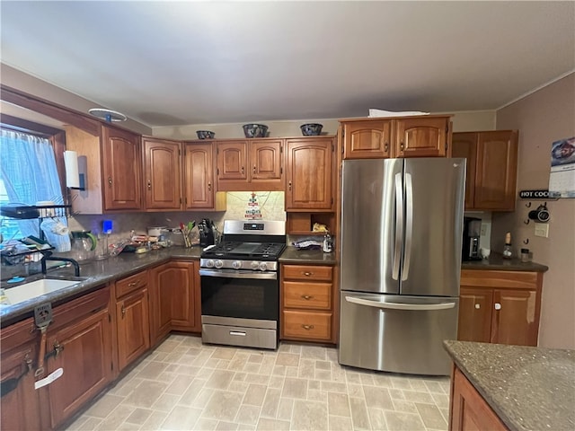 kitchen featuring sink, dark stone counters, and appliances with stainless steel finishes