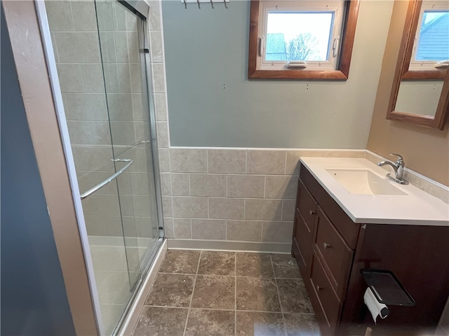 bathroom with vanity, walk in shower, and a wealth of natural light