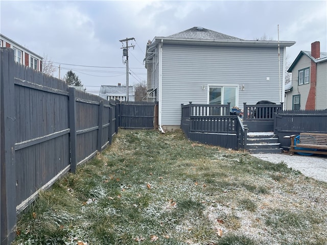 back of house featuring a wooden deck and a yard