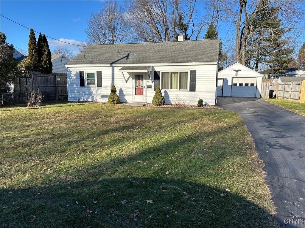 view of front of house with an outbuilding, a front lawn, and a garage