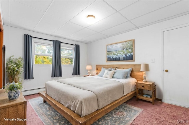 bedroom featuring a paneled ceiling, carpet flooring, and a baseboard heating unit