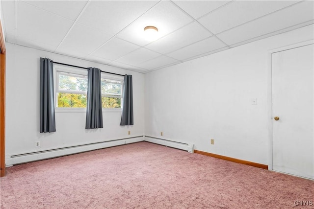 unfurnished room featuring a drop ceiling, carpet, and a baseboard heating unit