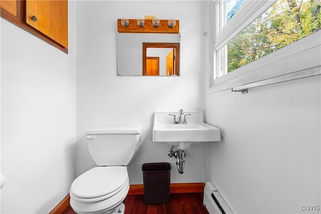 bathroom with wood-type flooring, a baseboard radiator, toilet, and sink