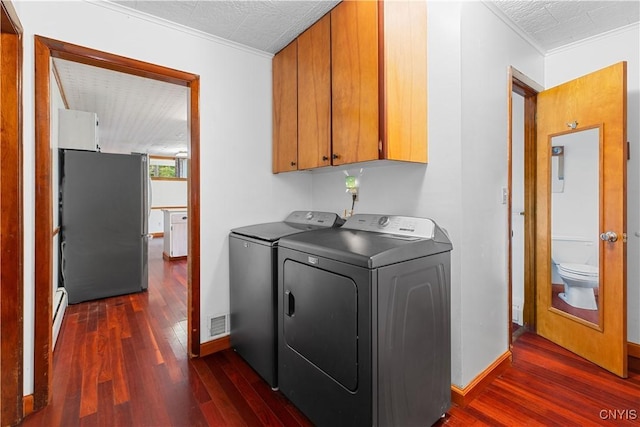 washroom featuring cabinets, ornamental molding, baseboard heating, independent washer and dryer, and dark hardwood / wood-style floors