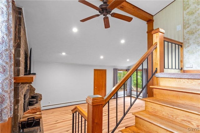 staircase featuring baseboard heating, vaulted ceiling with beams, ceiling fan, and hardwood / wood-style floors