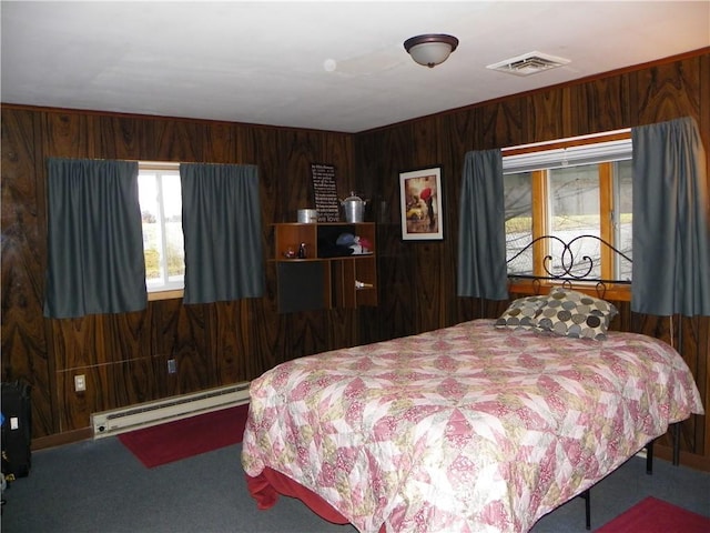 bedroom featuring wooden walls, carpet floors, and a baseboard radiator