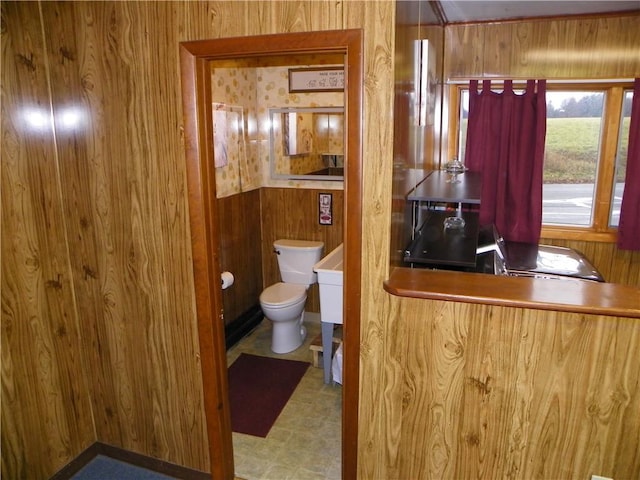 bathroom with wooden walls and toilet