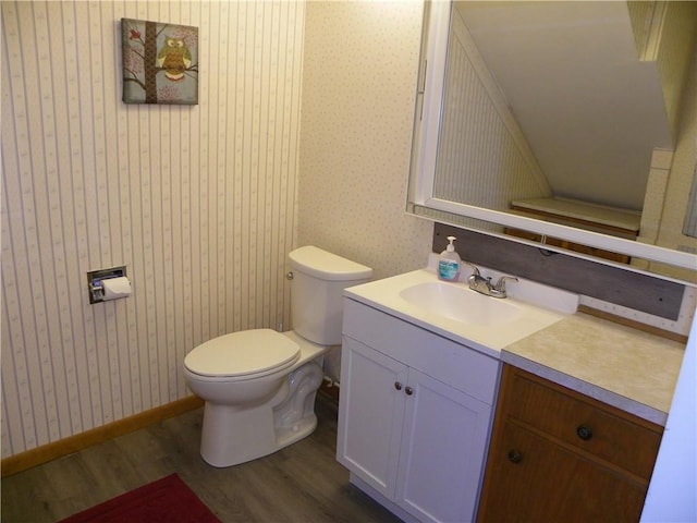 bathroom with hardwood / wood-style floors, vanity, and toilet