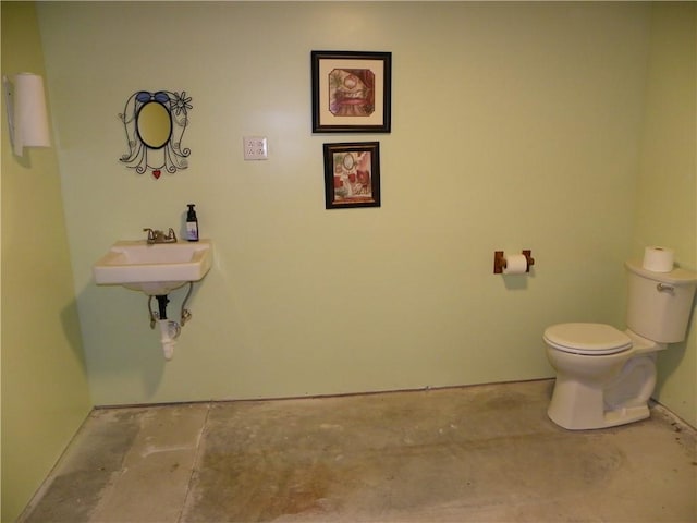 bathroom with concrete flooring, toilet, and sink