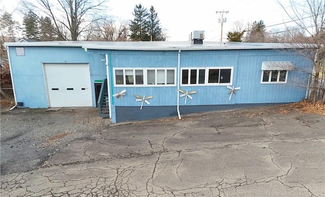 exterior space with central AC unit and a garage