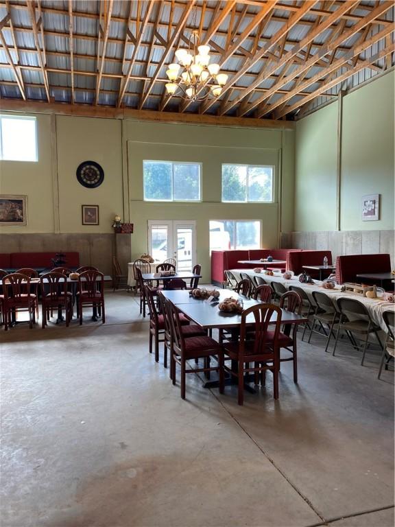 dining space featuring concrete floors, plenty of natural light, and a notable chandelier