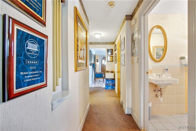 corridor featuring light colored carpet and sink