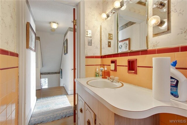 bathroom with vanity, tile walls, and hardwood / wood-style flooring