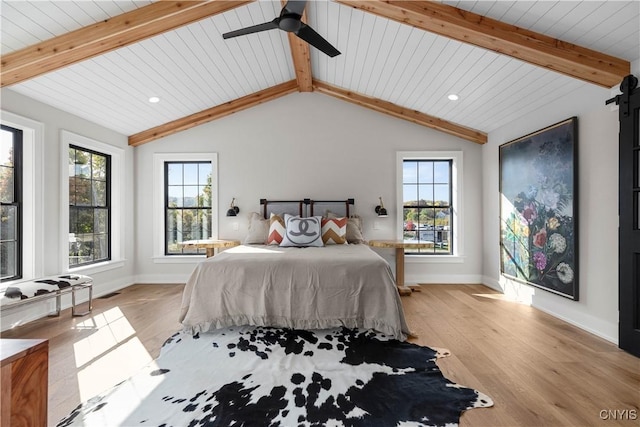 bedroom with multiple windows, ceiling fan, light hardwood / wood-style flooring, and vaulted ceiling with beams